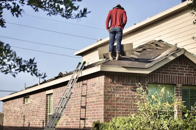 Professional roofer working on a residential roof in Red Barn